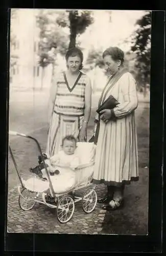 Foto-AK Zwei Frauen mit Kind im Kinderwagen, 1930