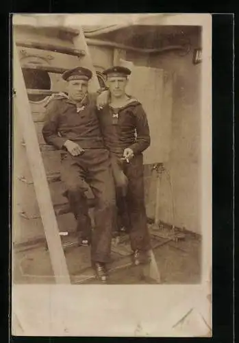 Foto-AK Zwei junge Matrosen in Uniform an Bord eines Schiffes, Mützenbänder mit SMS Deutschland