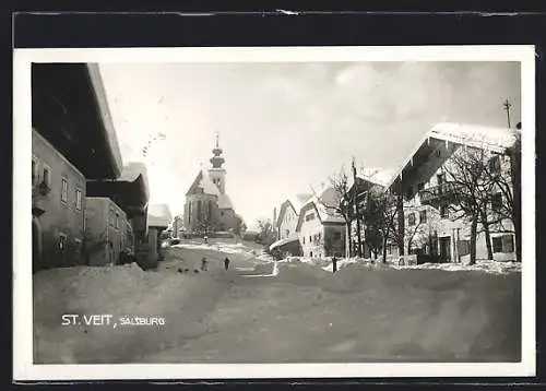 AK St. Veit /Pongau, Strassenpartie mit Kirche im Schnee