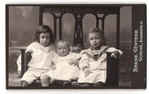 Fotografie Bernh. Günther, Goslar, Hokenstr. 11, Drei niedliche Geschwister auf grossem Stuhl