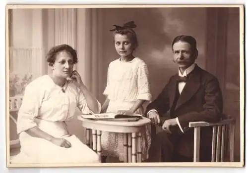 Fotografie Samson & Co., Halle a. S., Poststr. 9-10, Bürgerliches Ehepaar und die Tochter mit Schleife im Haar