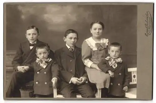 Fotografie Ernst Schroeter, Meissen, Junge adrette Brüder in schwarzen Anzügen mit ihrer schönen Schwester im Kleid
