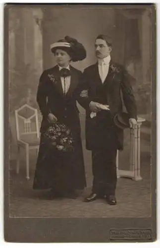 Fotografie Willibald Hartmann, Gross-Schönau i. S., Elegantes Paar, Dame mit Blumen