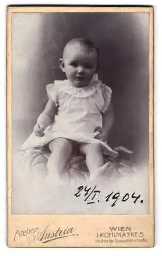 Fotografie Atelier Austria, Wien, Kohlmarkt 5, Baby im Strampler auf einem Sitzkissen, 1904