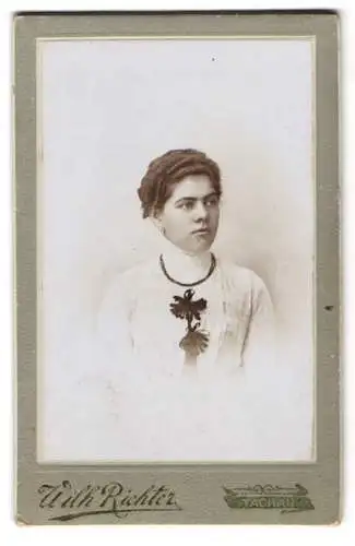 Fotografie Wilh. Richter, Tachau, Bahnhofstr. 33, Junge Frau mit welligem Haar und schwarzen Zierelementen an der Bluse