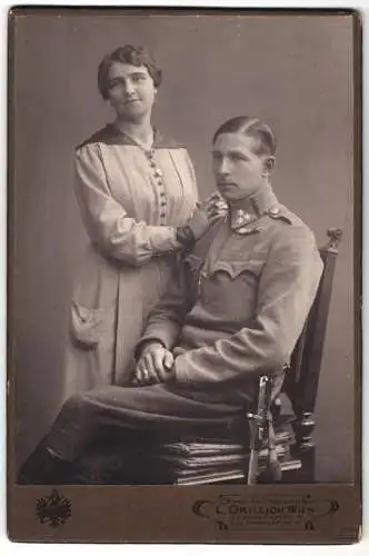 Fotografie L. Grillich, Wien, K.u.K. Offizier in Uniform mit Bandschnalle und Bajonett nebst seiner Frau