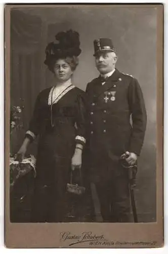 Fotografie Gustav Schubert, Wien, Brettenseerstr. 22, K.u.K. Marine Offizier in Uniform mit Orden und Säbel nebst Frau