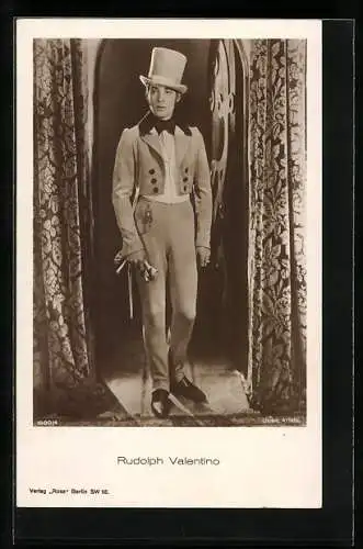 AK Schauspieler Rudolph Valentino im Anzug mit Zylinder in die Ferne schauend