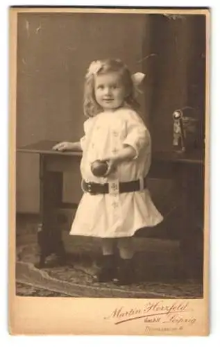 Fotografie Martin Herzfeld, Leipzig, Thomasgasse 4, Niedliches kleines Mädchen mit Gürtel und Ball in der Hand