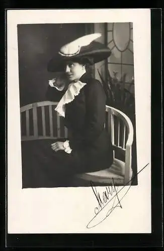 Foto-AK Dame mit schwarzem Hut sitzt auf Bank