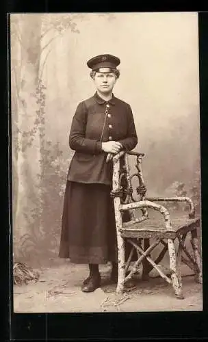 AK Strassenbahnerin in eleganter Arbeitskleidung an einem Stuhl stehend