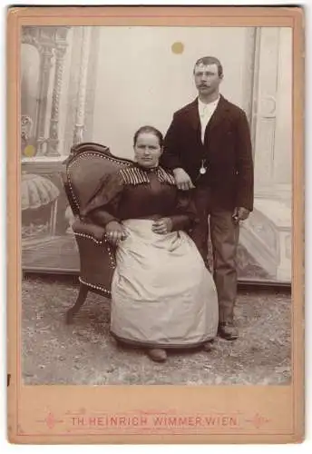 Fotografie Th. Heinrich Wimmer, Wien, Bürgerliches Ehepaar vor bemalter Kulisse