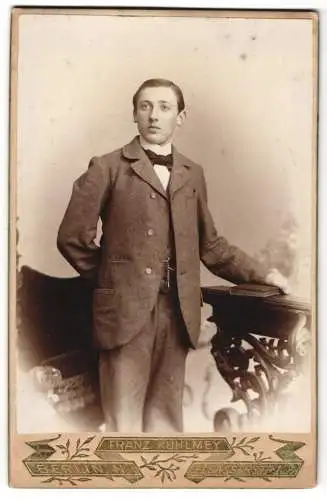 Fotografie Franz Kuhlmey, Berlin, Elsasserstr. 1-2, Junger Mann im Anzug mit Buch in der Hand