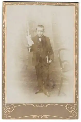 Fotografie Fotograf unbekannt, Junge mit Kerze in der Hand und Buch unter dem Arm
