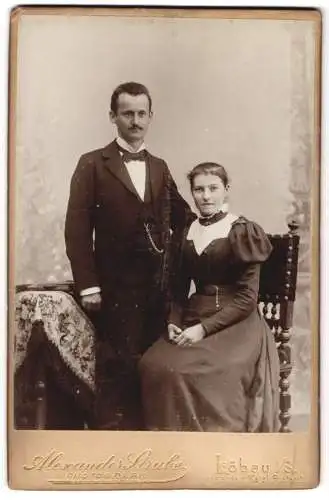 Fotografie Alexander Strube, Löbau i. S., Junges Ehepaar in Anzug und hochgeschlossenem Kleid