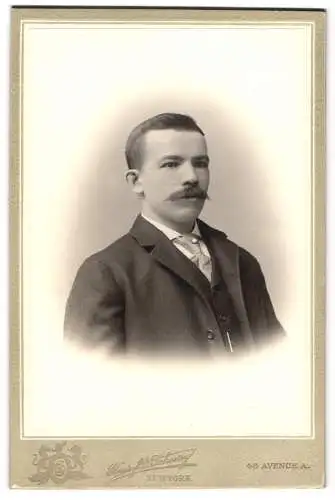 Fotografie Henry D. Schoerry, New York, 43 Avenue A., Junger Mann mit Schnauzbart in Anzug und gestreifter Krawatte