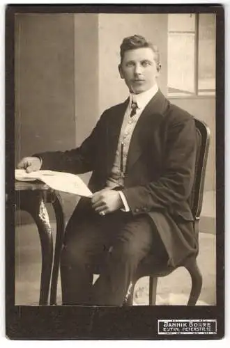 Fotografie Jannik Borre, Eutin, Peterstr. 12, Junger Mann im Anzug mit aufgeschlagenem Heft