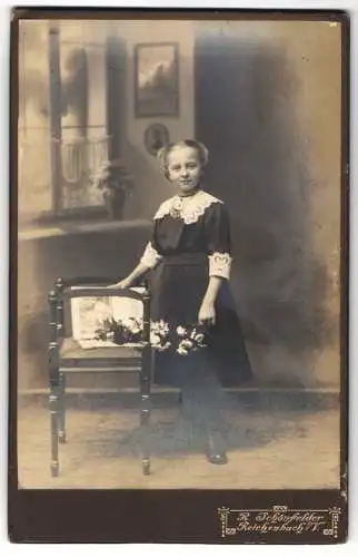 Fotografie R. Schönfelder, Reichenbach i. V., Kleines Mädchen in Kleid mit Spitzenkragen mit Blumenstrauss