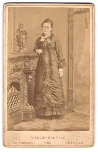 Fotografie Theodor Haertel, Potsdam, Charlottenstr. 25, Elegante Dame in tailliertem Kleid mit Schleife am Kragen