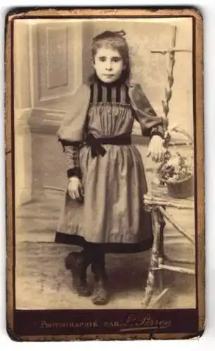 Fotografie Louis Perron, Paris, Kleines Mädchen in Kleid mit Samtdekor und Haarschleife