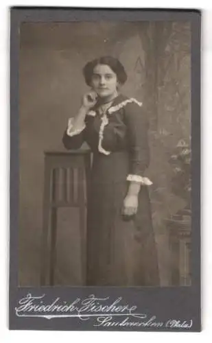 Fotografie Friedrich Fischer, Lauterecken /Pfalz, Junge Dame in dunklem Kleid mit weissen Rüschen, an Hocker gelehnt