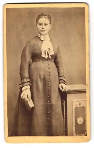 Fotografie Carl Leupold, Heidelberg, Anlagen 44, Junge Dame in tailliertem Kleid mit Buch in der Hand