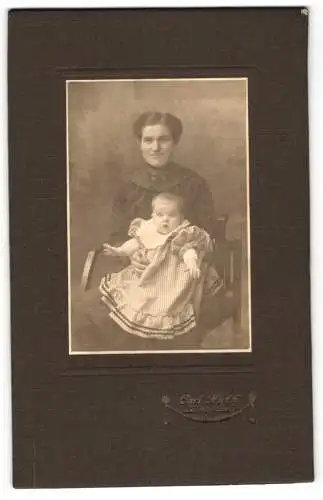 Fotografie Carl Huth, Lüdenscheid, Lächelnde junge Frau mit Kleinkind im Puffärmelkleidchen