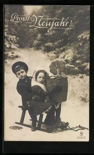 Foto-AK L.J. & F.F. Nr. 4230 /2: Kinderpaar auf Schlitten mit Kleeblatt, Neujahrsgruss