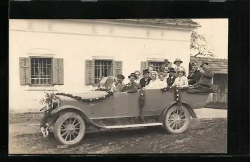 Foto-AK Festlich geschmücktes Auto, fröhlich posierende Festgesellschaft