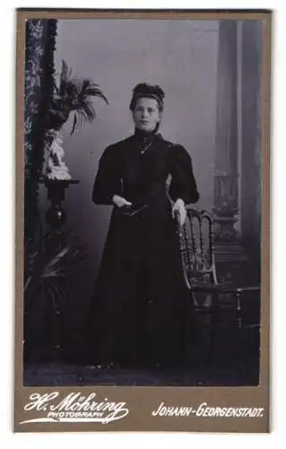 Fotografie H. Möhring, Johann-Georgenstadt, Elegante Dame in hochgeschlossenem Kleid mit Buch in der hand