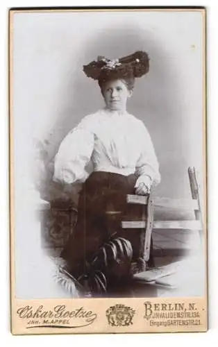 Fotografie Oskar Goetze, Berlin, Invaliden-Str. 134, Elegante Dame in hochgeschlossenem Kleid mit Hut