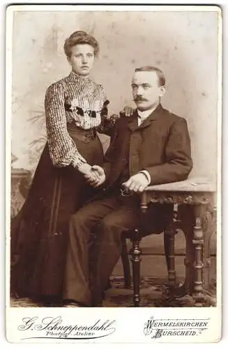 Fotografie G. Schneppendahl, Wermelskirchen, Junges schönes Paar in feiner dunkler Kleidung hält sich bei der Hand