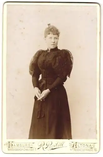 Fotografie R. Przibill, Altona, Reichenstr. 18, Schöne junge Frau im schwarzen taillierten Kleid mit Spitze und Brosche