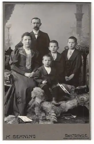 Fotografie H. Behning, Buxtehude, Junges elegantes Paar mit ihren drei niedlichen Söhnen in dunkler Kleidung