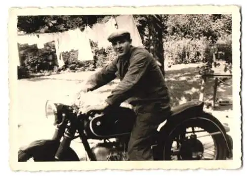 Fotografie Motorrad BMW, Mann mit Schiebermütze fährt Krad im Garten