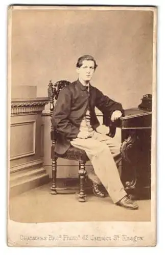 Fotografie Chalmers Bros., Glasgow, junger Schotte im Anzug sitzend am Sekretär