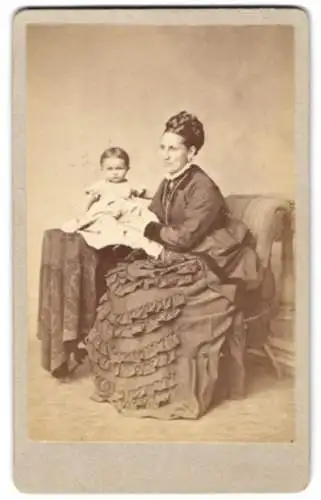 Fotografie F. Grill, Hanau, Mutter im dunklen Kleid mit ihrer Tochter auf dem Tisch