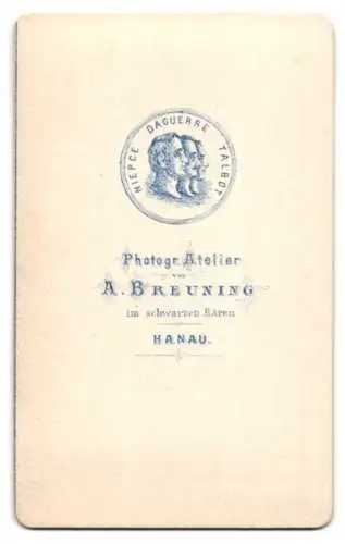 Fotografie A. Breuning, Hanau, niedliches kleines Mädchen im karierten Kleid vor einer Studiokulisse