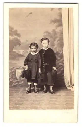 Fotografie F. Grill, Hanau, zwei niedliche kleine Knaben in Anzügen mit Mützen in der Hand, geprägter Trockenstempel