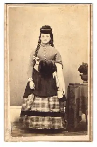 Fotografie C. F. G. Schmidt, Grand Rapids / MI, junge Amerikanerin im Kleid mit langen geflochtenen Zöpfen und Muff
