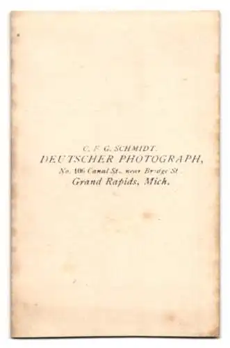 Fotografie C. F. G. Schmidt, Grand Rapids / MI, junge Amerikanerin im Kleid mit langen geflochtenen Zöpfen und Muff