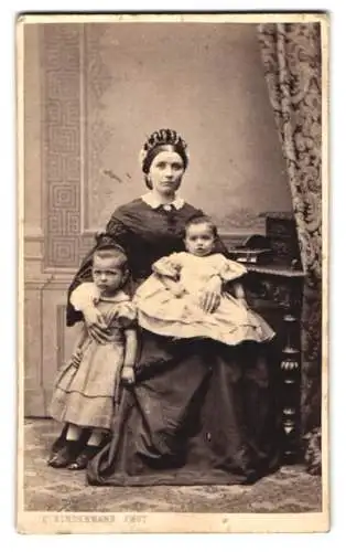 Fotografie C. Kindermann, Lübeck, junger Mutter mit ihren beiden Töchter auf dem Schoss und im Arm