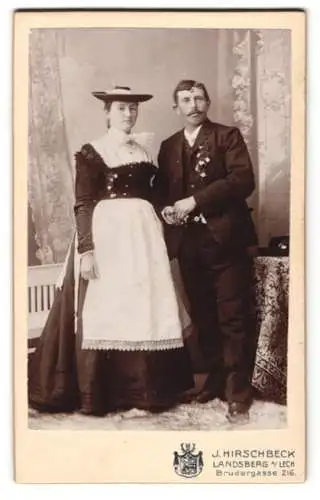 Fotografie J. Hirschbeck, Landsberg / Lech, junges Brautpaar im Trachtenkleid und im Anzug