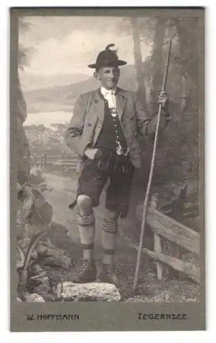 Fotografie W. Hoffmann, Tegernsee, junger Mann in bayerischer Tracht mit Lederhose und Wanderstab