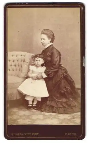 Fotografie Wilhelm Witt, Peine, junger Mutter im dunklen Kleid mit ihrer Tochter im weissen Kleidchen, Mutterglück