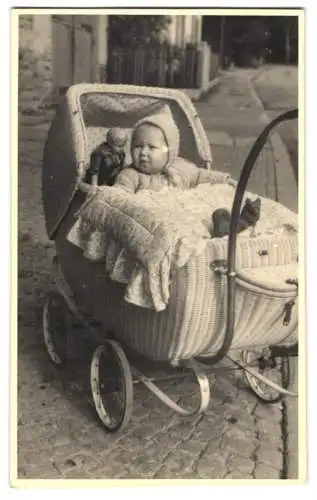 Fotografie kleines Kind im Kinderwagen mit Puppe