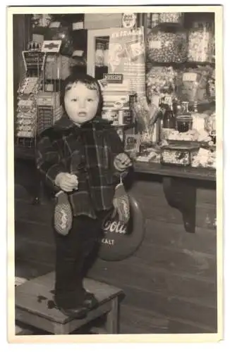 Fotografie niedliches kleines Kind am Tresen eines Süssigkeiten Geschäft, Coco Cola Schild
