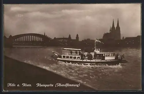 AK Köln a. Rh., Rheinpartie am Abend, Stadtpanorama mit Schiff