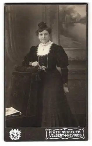 Fotografie H. Ottenstreuer, Velbert, Elegante junge Frau in dunklem Kleid mit weissem Kragen