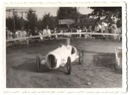 Fotografie Auto, Rennwagen, Knabe steuert Seifenkiste